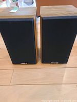 Pair of Tannoy C-5 bookshelf speakers, front view with black fabric grills and Tannoy logos.