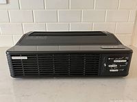 Side view of black Oreck air purifier showing vents and control panel area