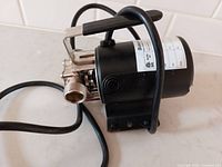 Side view of Burcam water pump showing black motor housing, power cord, and metal handle.