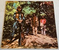 Front cover of the Green River vinyl album showing band members standing in a wooded area, one holding a guitar.