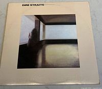 Front cover of Dire Straits vinyl album showing artwork of modern architecture interior and a shadowy figure.
