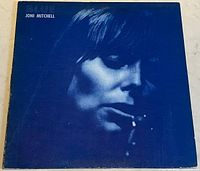 Front cover of the vinyl album showing a blue-tinted side-lit portrait of Joni Mitchell against a dark blue background with her name in white text in the upper left corner.