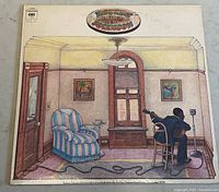 Front cover of the Robert Johnson vinyl record album showing illustrated interior scene of man playing guitar in a room.