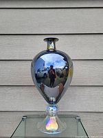 Full view of reflective decorative flower vase showing shape, finish and standing on base.