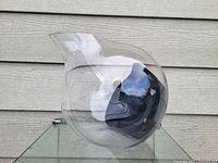 Large slanting glass flower pot shown from an angled perspective revealing its curvature and black section inside.