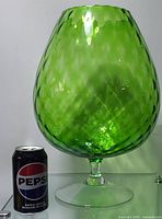 Large green textured wine glass displayed next to a can of Pepsi for size comparison. Shows body and base with diamond texture and glossy finish.