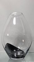 Clear glass vase with a distinctive black bottom, teardrop shape, displayed against white background.