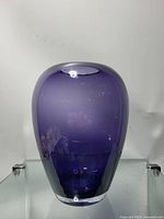 Front view showing the full height and shape of the purple gradient glass vase on a glass shelf.
