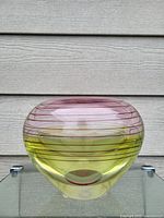 Front view of large Irish art glass bowl with yellow and purple colors and horizontal swirl lines.
