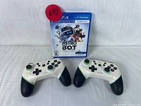 Front view of sealed Astro Bot Rescue Mission PS4 VR game and two wireless controllers.