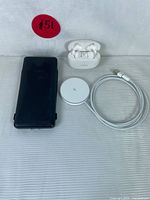 Power bank, wireless charger with cable, and Bluetooth earbuds with charging case shown from front.