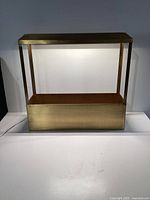 Front view of brass planter with integrated grow light powered on