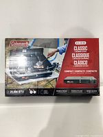 Box front showing Coleman Classic 2 burner portable camping stove with 20,000 BTU rating.