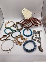 Photo showing all bracelets laid out including bangles, beaded, charm and metal link bracelets.
