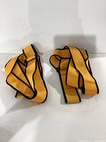Two yellow forearm forklift lifting straps laid out flat showing full length and detail.