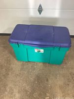 Full view of the 33 gallon storage tote showing green base and purple lid.