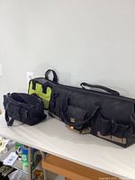 Wide shot of three assorted tool bags on white surface, showing size and shape differences.