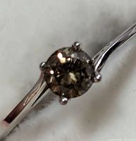Close-up front angle of the round diamond in 10KT white gold prong setting, showing the diamond color and clarity.