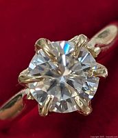 Front view of ring showing round moissanite center stone in six-prong setting