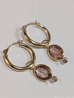 Front view of both earrings showing hoop design with tourmaline and diamond dangles on white background