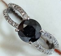 Angled top-down view showing central black diamond and split shank pavé diamonds