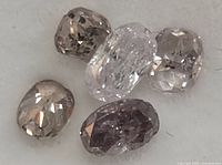 Close-up of assorted faceted diamonds showing different shades of pink and light brown, highlighting cut and clarity.