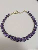 Full view of the silver amethyst bracelet showing the polished teardrop amethyst beads and lobster claw clasp.