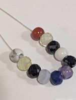 Close up of the faceted beads showing the variation in colors and faceting detail on a silver necklace chain.