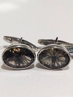 Front view of the silver cufflinks highlighting the oval smokey quartz stones with laser cut facets.