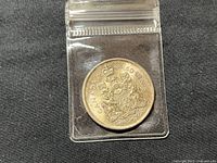 Image of the reverse side of the 1966 Canadian 50-cent silver coin showing the Canadian Coat of Arms and denomination '50 CENTS CANADA 1966'. Coin is in a clear resealable plastic sleeve.