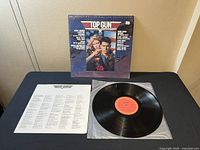 Top Gun 1986 soundtrack vinyl album with original shrink-wrap, album cover, and lyric insert displayed on a table.