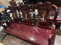 Full view of the antique solid rosewood Chinese bench displaying high backrest with three inlaid mother-of-pearl panels, carved dragon head crest, curved arms, polished finish and seat base.