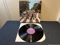 Front cover of Abbey Road album by The Beatles showing the band crossing the iconic crosswalk on Abbey Road.