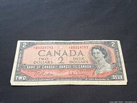 Front side of 1954 Canadian $2 replacement banknote with serial numbers, Queen Elizabeth II portrait, and signatures.