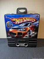 Front view of the closed Hot Wheels carrying case showing the colorful graphic of a red sports car and Hot Wheels logo