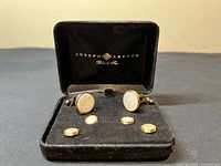 Front view of the Joseph Abboud Black Tie cufflink and shirt stud set in black velvet box showing 2 cufflinks and 4 studs with mother-of-pearl inlays