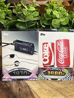 Two 2011 Topps nostalgia trading card sets, one featuring the Walkman release in the 1970s, the other showcasing New Coke from the 1980s.