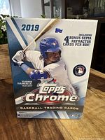 Front view of the sealed 2019 Topps Chrome box showing Vladimir Guerrero Jr. image and product details including 4 bonus sepia refractor cards per box.