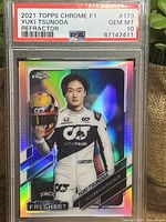 Front of 2021 Topps Chrome F1 trading card showing Yuki Tsunoda in racing suit holding helmet. Holographic Refractor finish visible.