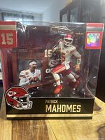 Front view of boxed Patrick Mahomes figure showing figure in white Chiefs uniform number 15, sealed in original packaging with clear plastic window.