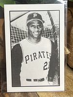 Front of the Roberto Clemente baseball card showing black-and-white portrait in Pirates uniform with batting cage background.