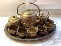 Full set displayed on countertop: tray, kettle, teapot, sugar bowl, six cups