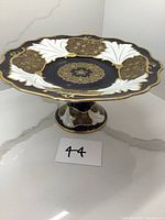Full view of the large black, white and gold Weimar porcelain pedestal dish showing its shape and size.