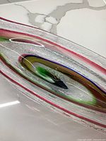 Close-up showing the colored glass accents and textured surface of the oblong bowl.