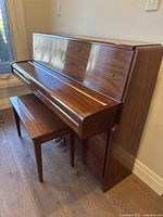 Right-side angle view of walnut Yamaha upright piano with bench in front