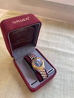 Vintage Gruen wristwatch displayed in original red velvet box with gray interior.