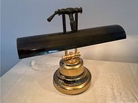 Full view of the vintage brass table lamp showing the brass base, adjustable arm, and black shade.