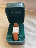 Vintage Oscar de la Renta quartz wristwatch in original green box with padded interior and brand name on lid and behind watch.