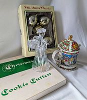 Photo showing Sadler Christmas teapot, two boxes of vintage glass ball ornaments (gold and white), clear glass angel candleholder, and cookie cutter decorations box.