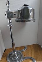 Full view of the chrome desk lamp casing showing the detailed lamp shade and adjustable arm.